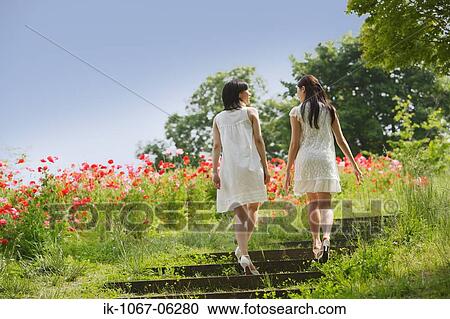 Two young women walking on stairs in garden View Large Photo Image Stock Image - Two young women walking on stairs in garden. Fotosearch