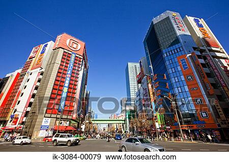 Vehicles crossing road at street with commercial buildings View Large Photo Image Stock Photo - Vehicles crossing road at street with commercial buildings. Fotosearch
