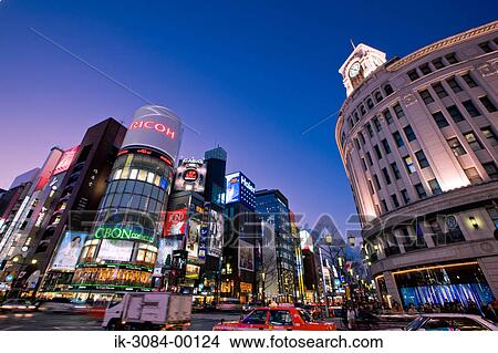 Picture - Vehicles on road with illuminated buildings in nighttime. Fotosearch