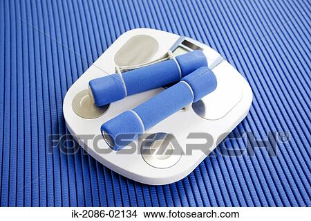 Weighing machine with dumbbells lying on mat View Large Photo Image Picture - Weighing machine with dumbbells lying on mat. Fotosearch