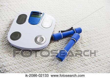 Stock Image - Weighing machine with dumbbells. Fotosearch