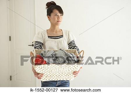 Woman carrying laundry basket View Large Photo Image Stock Photo - Woman carrying laundry basket. Fotosearch