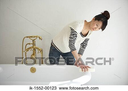 Woman cleaning bath tub in bathroom View Large Photo Image Stock Image - Woman cleaning bath tub in bathroom. Fotosearch