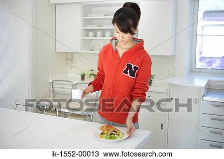 Woman having food in kitchen View Large Photo Image Stock Image - Woman having food in kitchen. Fotosearch