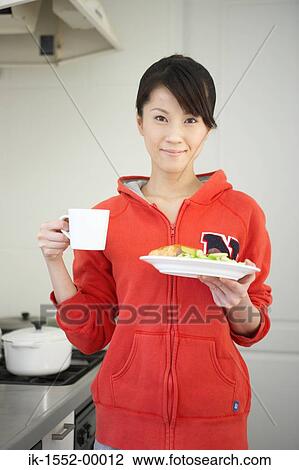 Woman holding plate of snacks with a cup of coffee View Large Photo Image Stock Image - Woman holding plate of snacks with a cup of coffee. Fotosearch