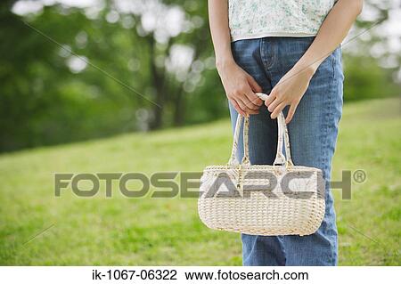 Stock Image - Woman holding white purse. Fotosearch