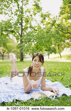 Stock Photograph - Woman Laying Down on Blanket. Fotosearch