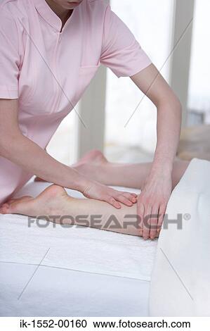 Woman massaging legs of a person View Large Photo Image Stock Image - Woman massaging legs of a person . Fotosearch