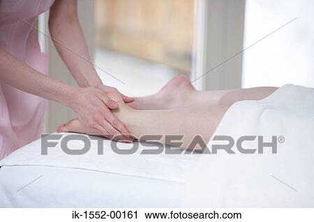 Woman massaging legs of a person View Large Photo Image Stock Image - Woman massaging legs of a person. Fotosearch