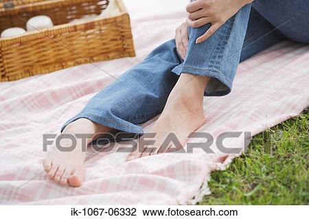 Woman sitting on the bed sheet holding legs View Large Photo Image Stock Image - Woman sitting on the bed sheet holding legs. Fotosearch