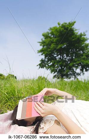 Stock Photograph - Woman sleeping with book covering face. Fotosearch