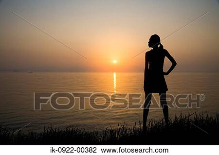Woman Standing on the Waterside in Sunset View Large Photo Image Stock Image - Woman Standing on the Waterside in Sunset. Fotosearch