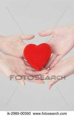 Stock Image - Women Holding Heart in Their Hands. Fotosearch