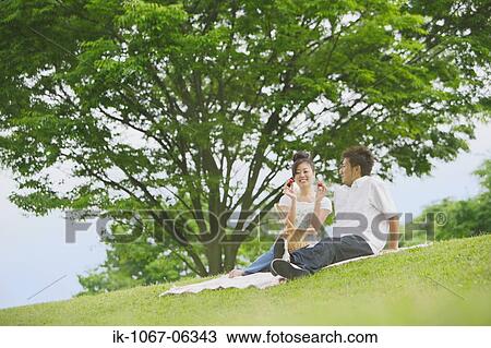 Young couple having picnic in park View Large Photo Image Stock Image - Young couple having picnic in park. Fotosearch