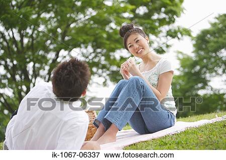 Young couple having picnic in park View Large Photo Image Stock Photo - Young couple having picnic in park. Fotosearch