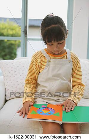 Stock Image - Young Girl Looking at a Book. Fotosearch