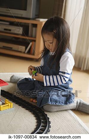 Picture - Young Girl Playing with Toy Trains. Fotosearch
