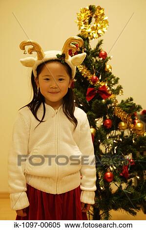 Stock Photography - Young Girl Standing By a Christmas Tree. Fotosearch
