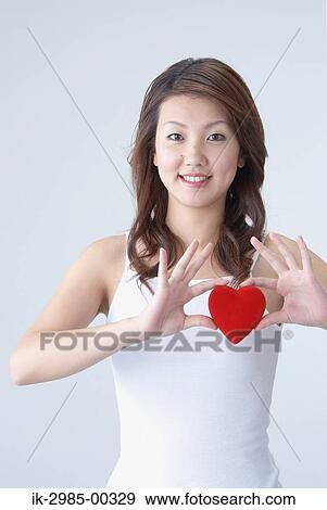 Stock Photo - Young Japanese Woman Holding Heart. Fotosearch