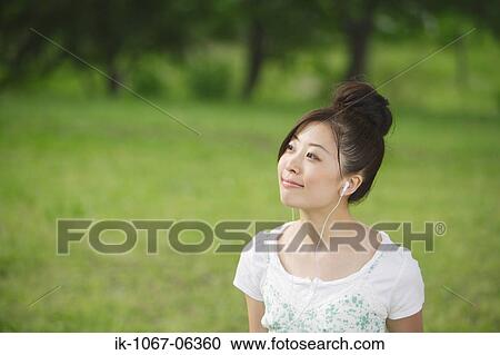 Young Japanese woman listening music View Large Photo Image Stock Image - Young Japanese woman listening music. Fotosearch