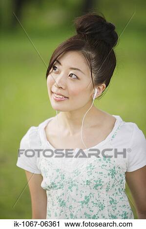 Young Japanese woman listening music View Large Photo Image Stock Image - Young Japanese woman listening music. Fotosearch