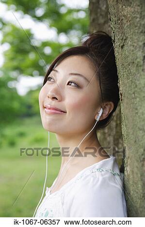 Stock Photo - Young Japanese woman listening music. Fotosearch
