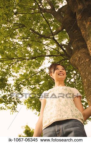 Young Japanese woman looking at tree View Large Photo Image Stock Photography - Young Japanese woman looking at tree. Fotosearch