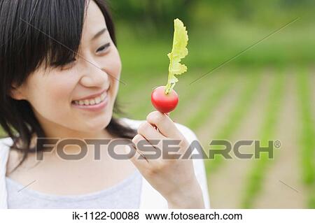 Stock Photo - Young smiling woman holding turnip. Fotosearch