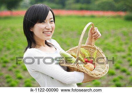 Young smiling woman holding vegetables basket View Large Photo Image Stock Image - Young smiling woman holding vegetables basket. Fotosearch