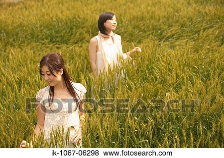 Young smiling women standing in wheat field View Large Photo Image Stock Photo - Young smiling women standing in wheat field. Fotosearch