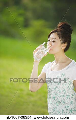 Picture - Young woman drinking glass of water. Fotosearch