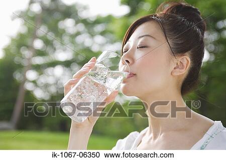 Stock Image - Young woman drinking glass of water. Fotosearch