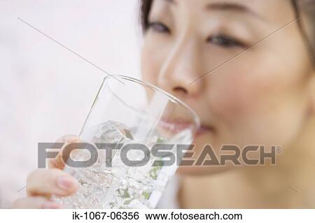 Stock Photograph - Young woman drinking glass of water. Fotosearch