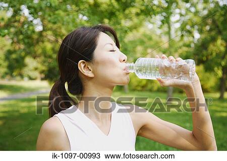 Stock Image - Young Woman Drinking Water. Fotosearch