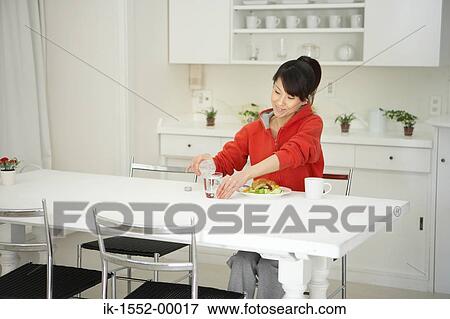 Young woman having breakfast at dinette View Large Photo Image Stock Photo - Young woman having breakfast at dinette. Fotosearch