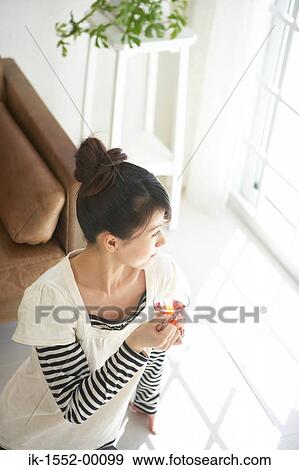 Stock Photo - Young woman having herbal tea. Fotosearch