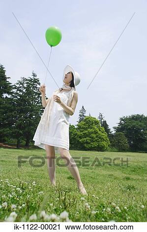 Young woman holding a balloon View Large Photo Image Stock Image - Young woman holding a balloon. Fotosearch