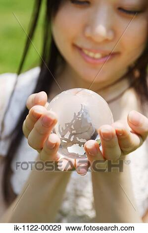 Stock Photo - Young woman holding a globe. Fotosearch