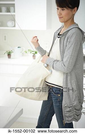Young woman holding bag View Large Photo Image Stock Image - Young woman holding bag. Fotosearch