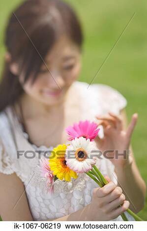 Stock Photo - Young woman holding flowers. Fotosearch