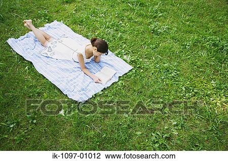 Young Woman Laying Down Reading a Book View Large Photo Image Stock Image - Young Woman Laying Down Reading a Book. Fotosearch