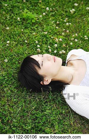 Stock Photograph - Young woman sleeping on grass . Fotosearch