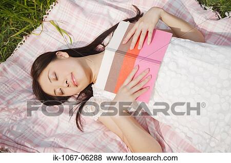 Stock Photo - Young woman sleeping with book. Fotosearch