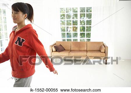 Young woman walking in a room View Large Photo Image Stock Photography - Young woman walking in a room. Fotosearch