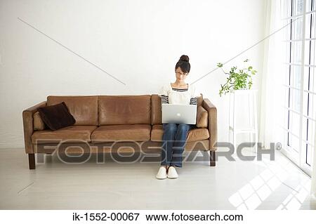 Young woman working from home on a laptop computer View Large Photo Image Stock Photo - Young woman working from home on a laptop computer. Fotosearch