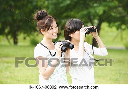 Young women looking through binoculars View Large Photo Image Stock Image - Young women looking through binoculars. Fotosearch
