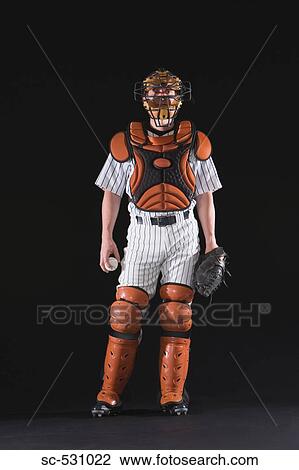 Stock Image - A baseball catcher standing with ball. Fotosearch