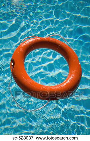 Stock Photo - An orange life ring floating in water. Fotosearch