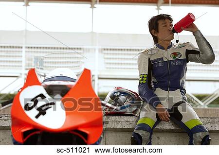 Asian racing motor biker drinking from flask View Large Photo Image Stock Image - Asian racing motor biker drinking from flask. Fotosearch