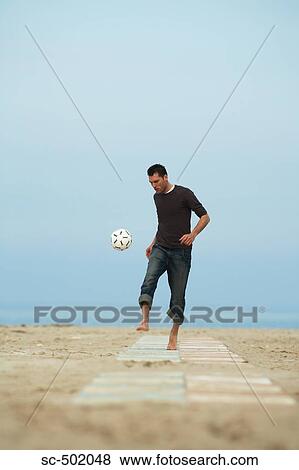 Stock Photo - Barefoot male with soccer ball. Fotosearch